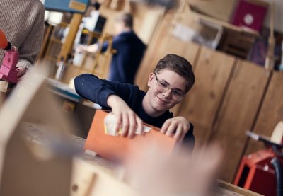 Elev slipar träfigur på träslöjden