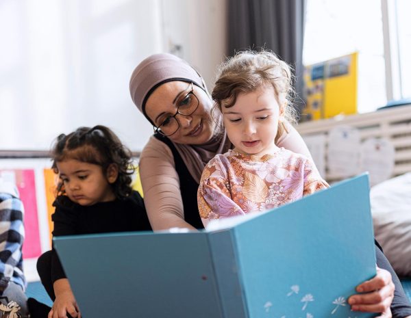 Barn och pedagog som läser tillsammans.