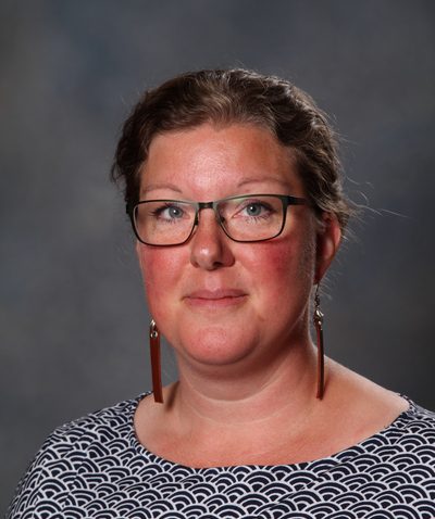 Susanna har svarta glasögon och långa örhängen.