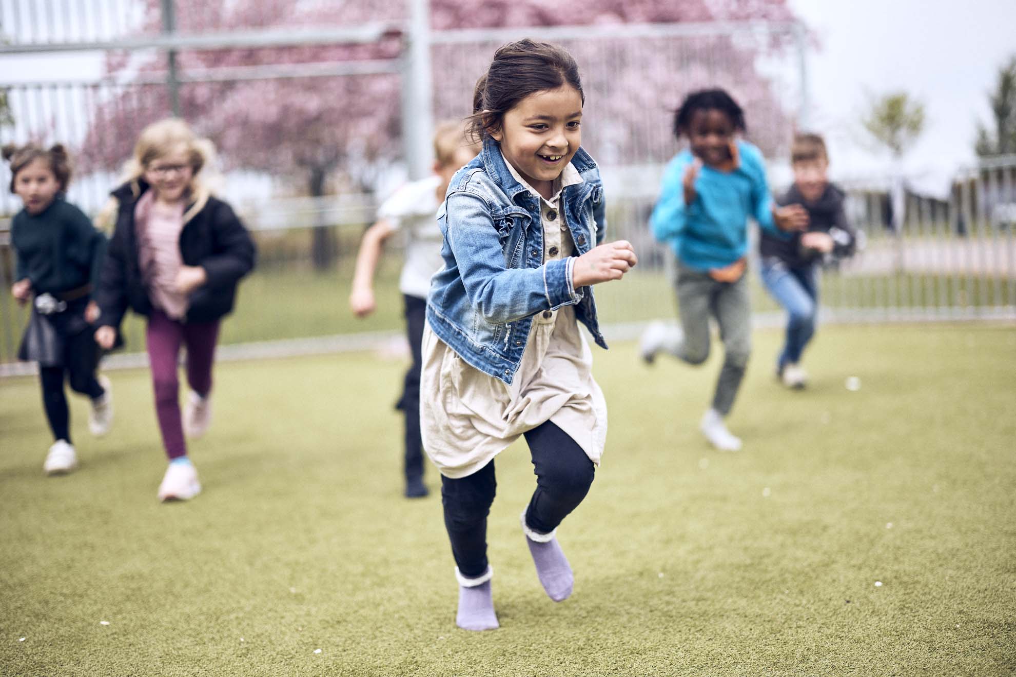 Barn på en Vittraskola springer på en gräsmatta.