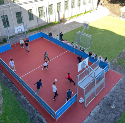 Elever spelar fotboll på multiarenan på Vittra Örebros skolgård.