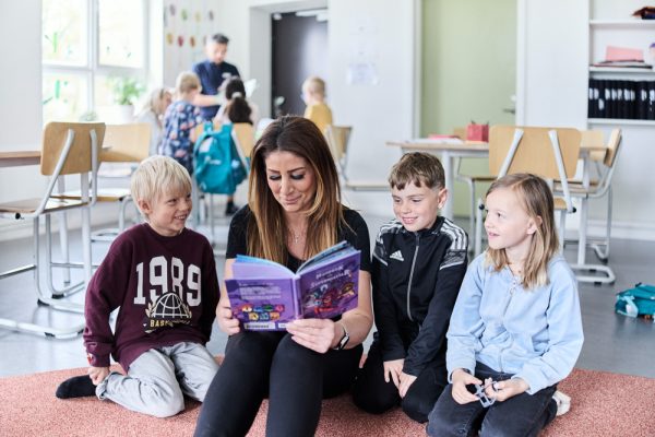 pedagog läser för tre barn