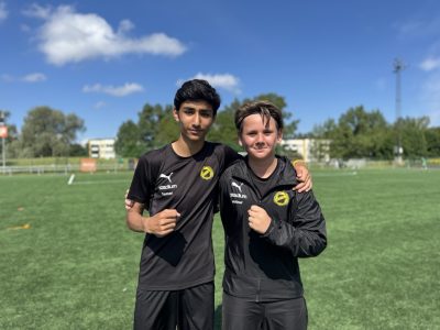 Två elever iklädda svart matchställ