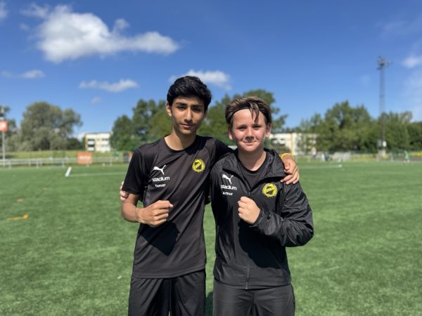 Två elever iklädda svart matchställ