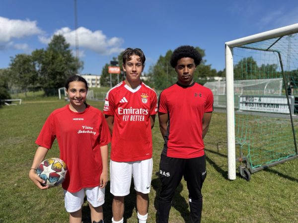 Tre elever iklädda rött matchställ