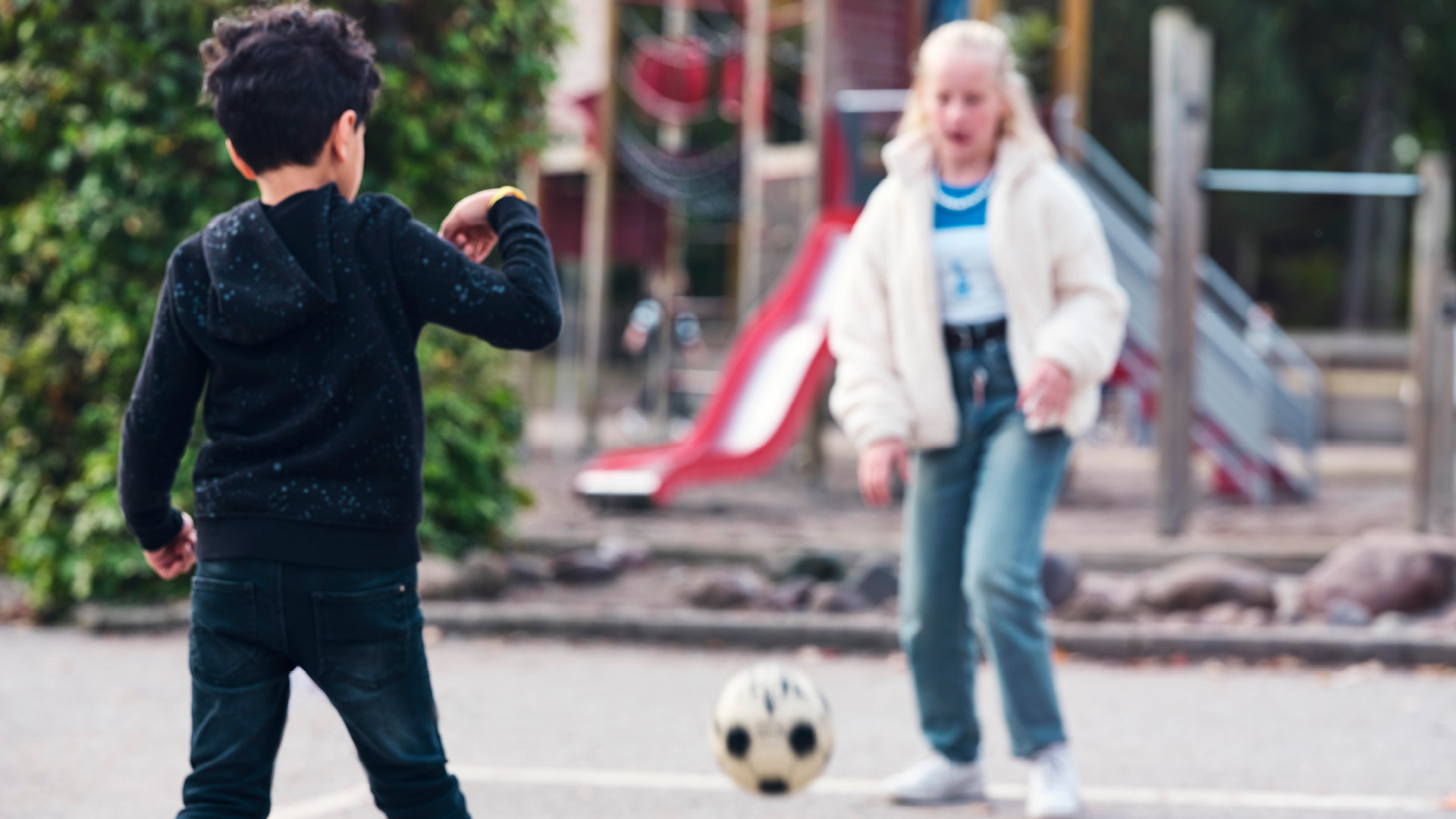 Två fritidselever på Vittra som spelar fotboll på skolgården