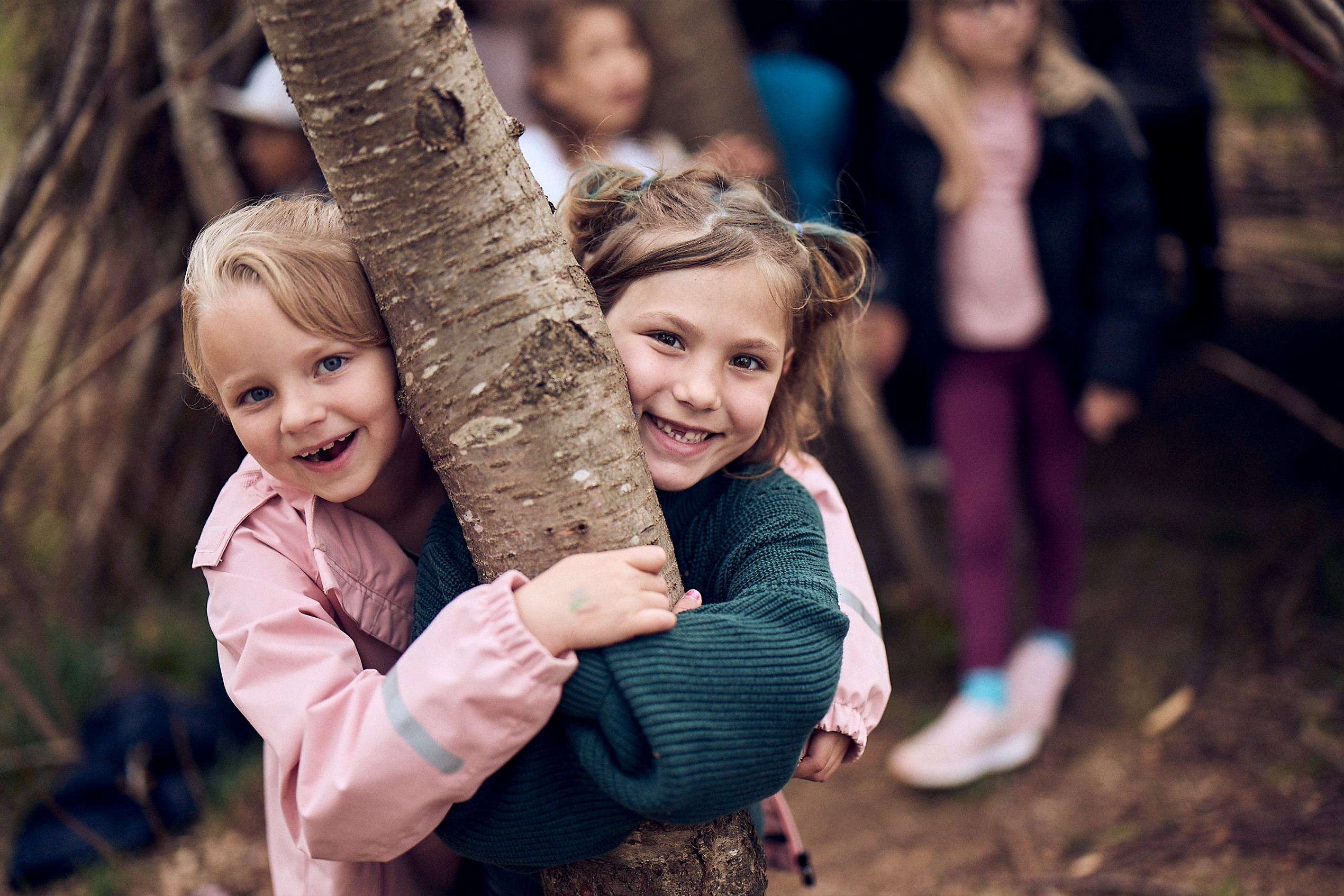 Två elever kramar ett träd