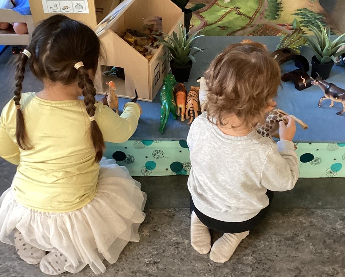 Två elever leker med djurleksaker