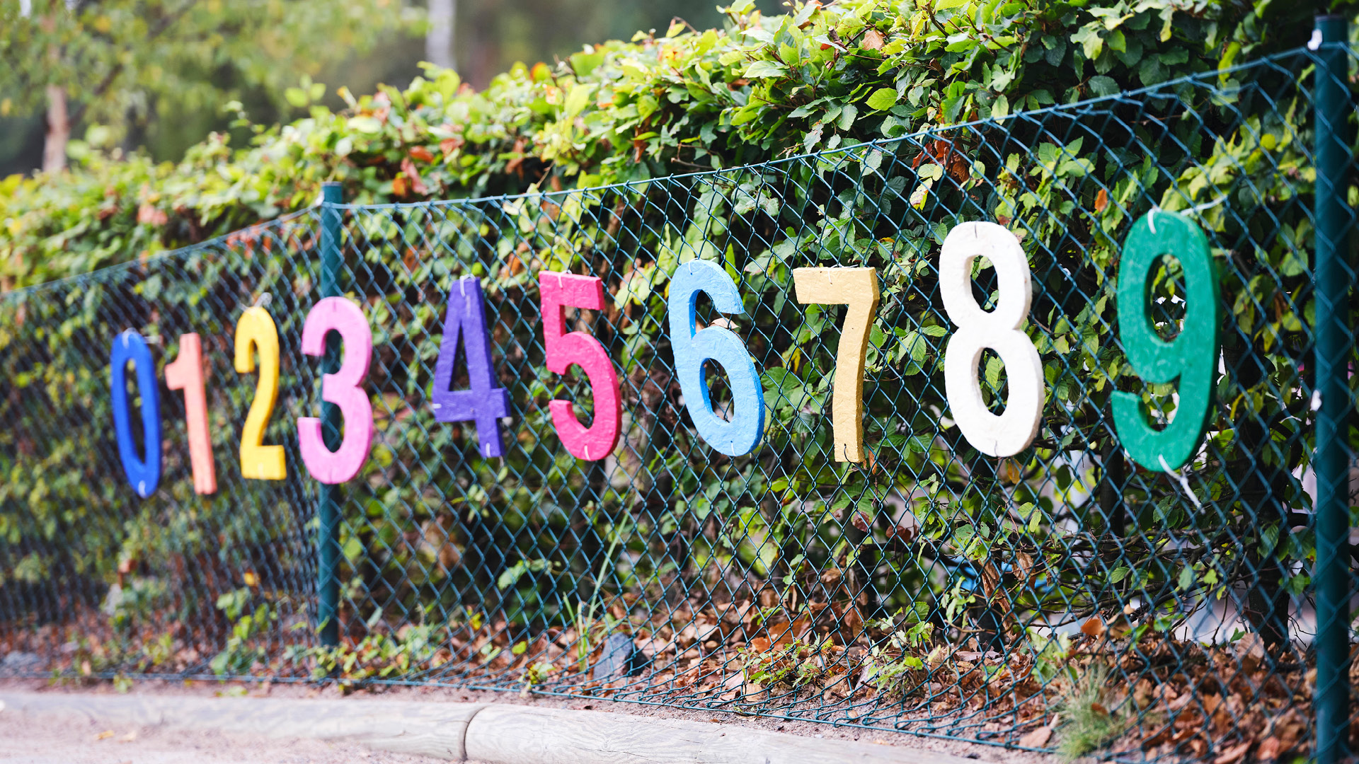 Ett staket vid Vittra som är dekorerat med siffror i olika färger