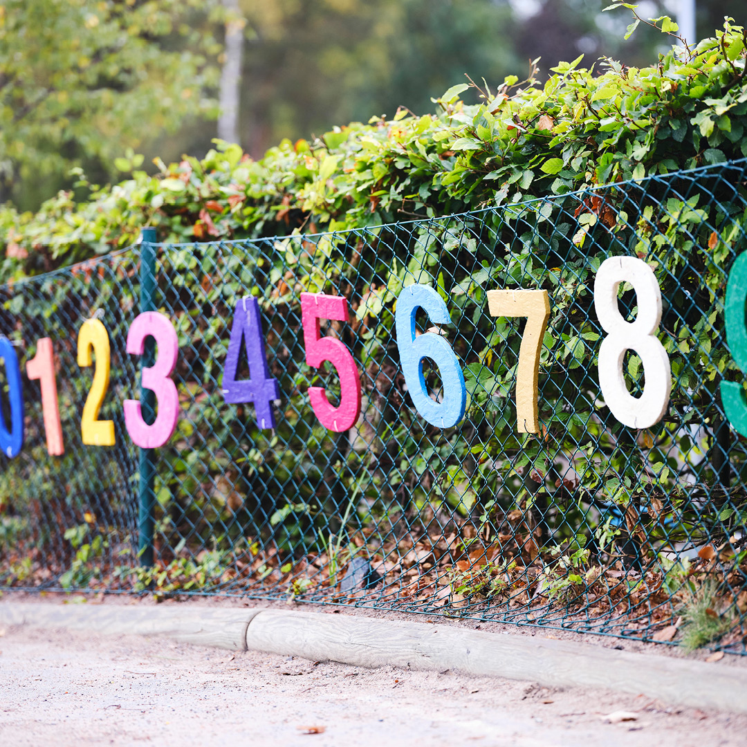 Ett staket utanför Vittra dekorerat med färgglada siffror
