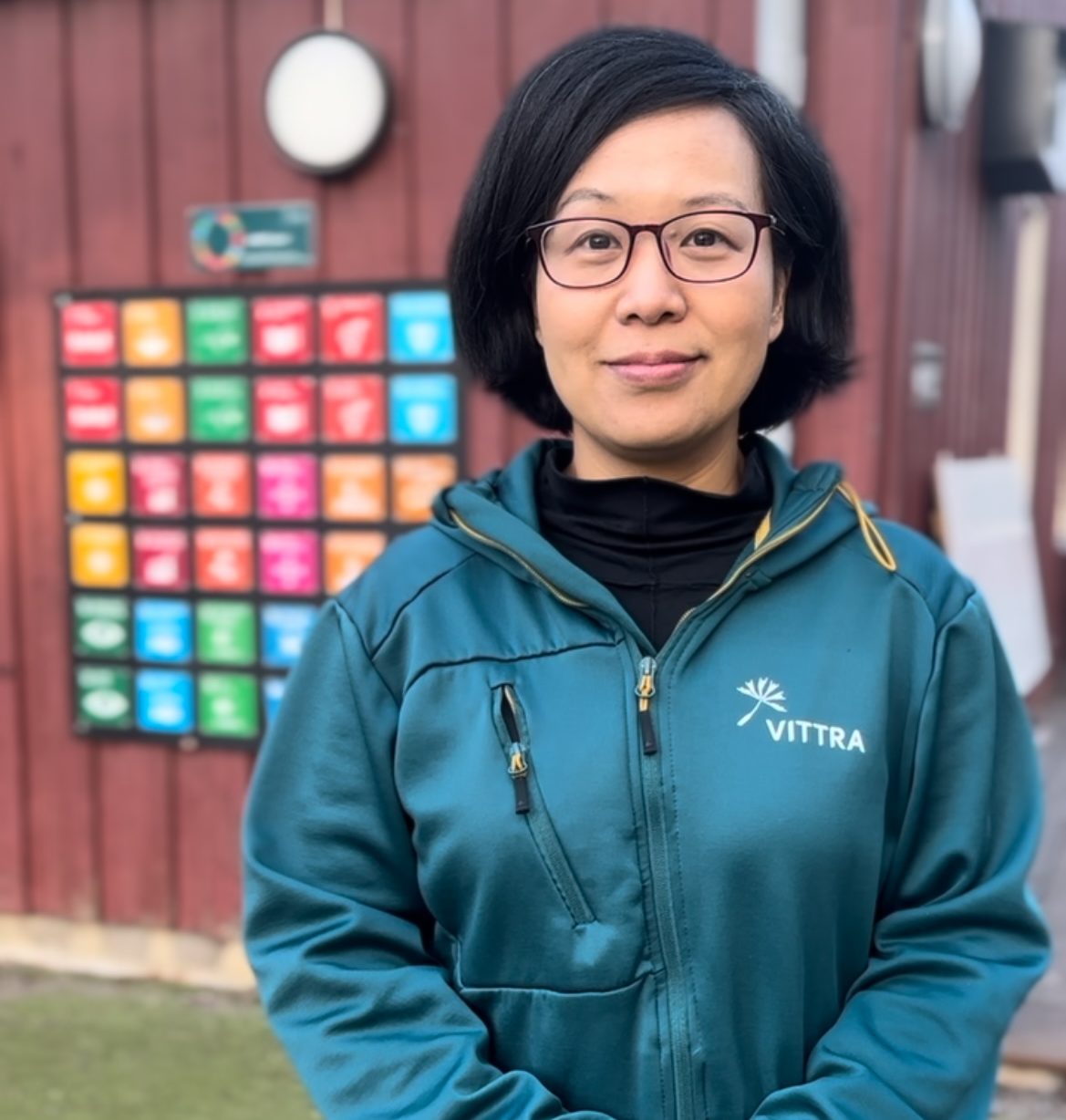 Läraren Ann står utanför skolans lokaler på skolgården.