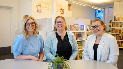 Tre lärare sitter bredvid varandra och ler in i kameran.