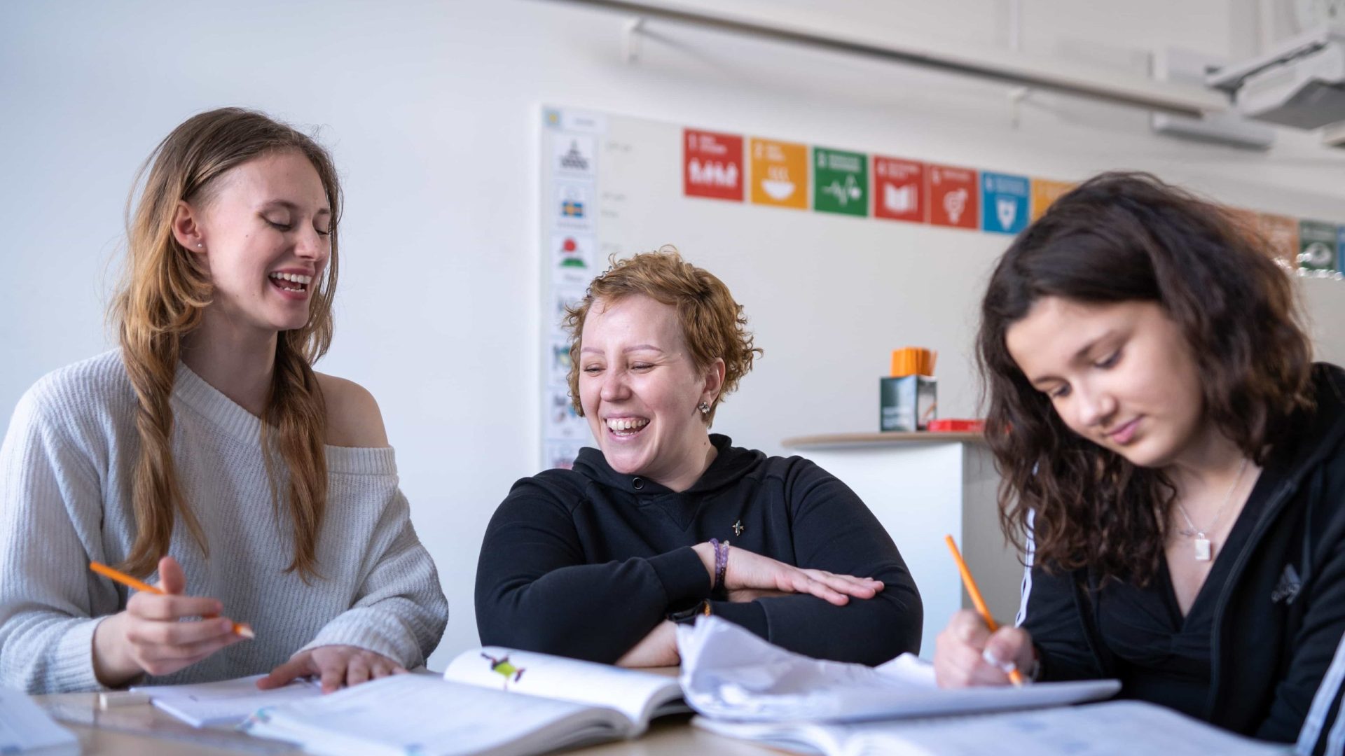 Två högstadieelever på Vittra Södermalm får hjälp av en lärare under en lektion.