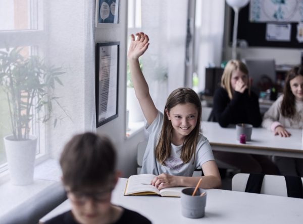 Elev som räcker upp handen.