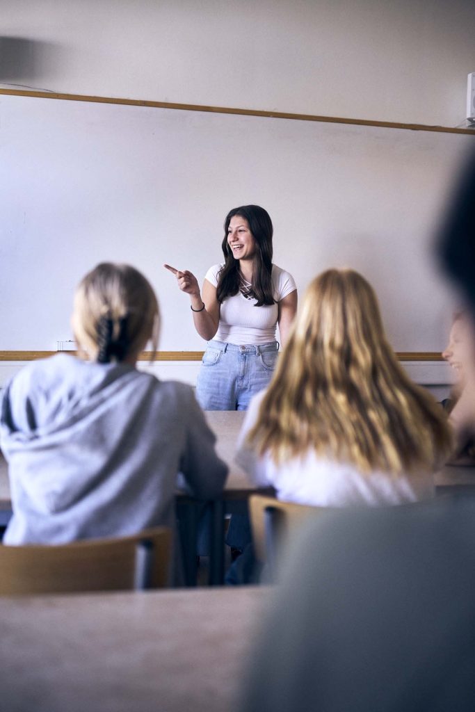 En elev står framme vid tavlan och pratar inför klassen
