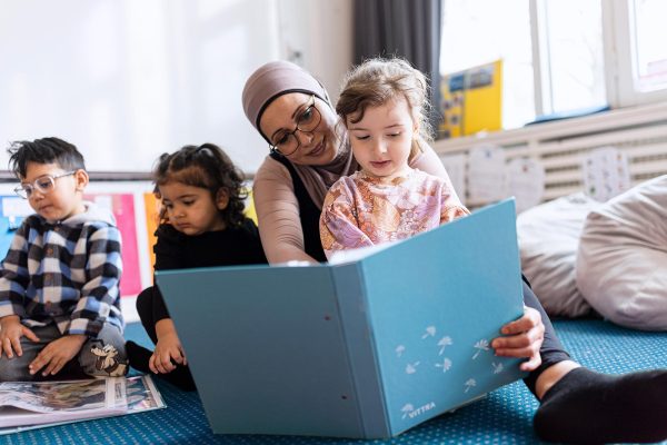 Barn och pedagog som läser tillsammans.