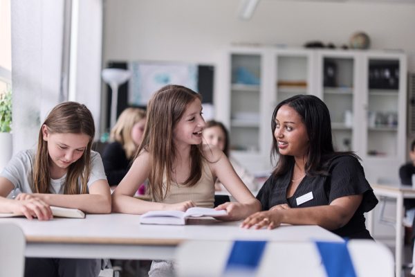 Elever och lärare som läser i klassrummet.